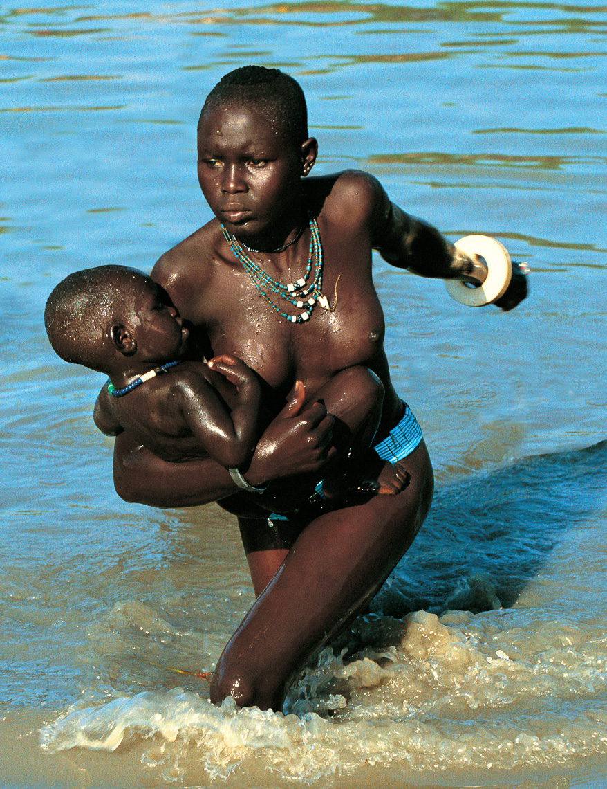 Dinka Mother Carrying Child Across River, South Sudan